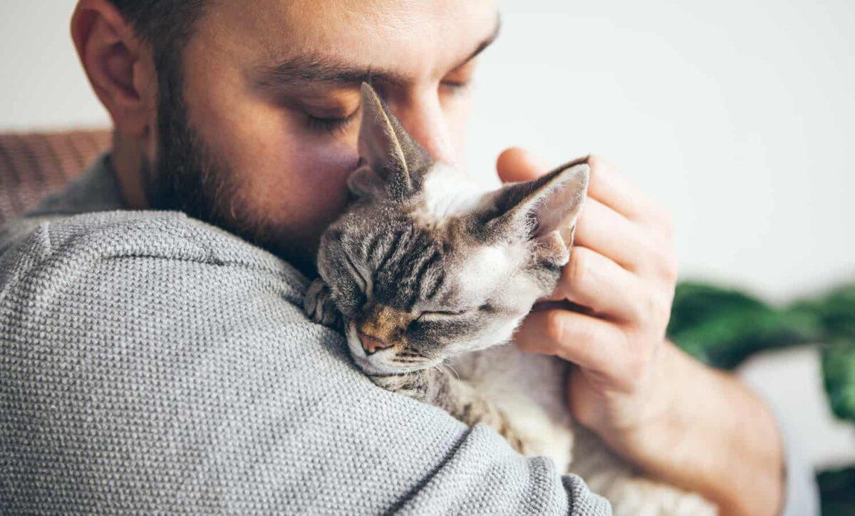 A man snuggles his cat.